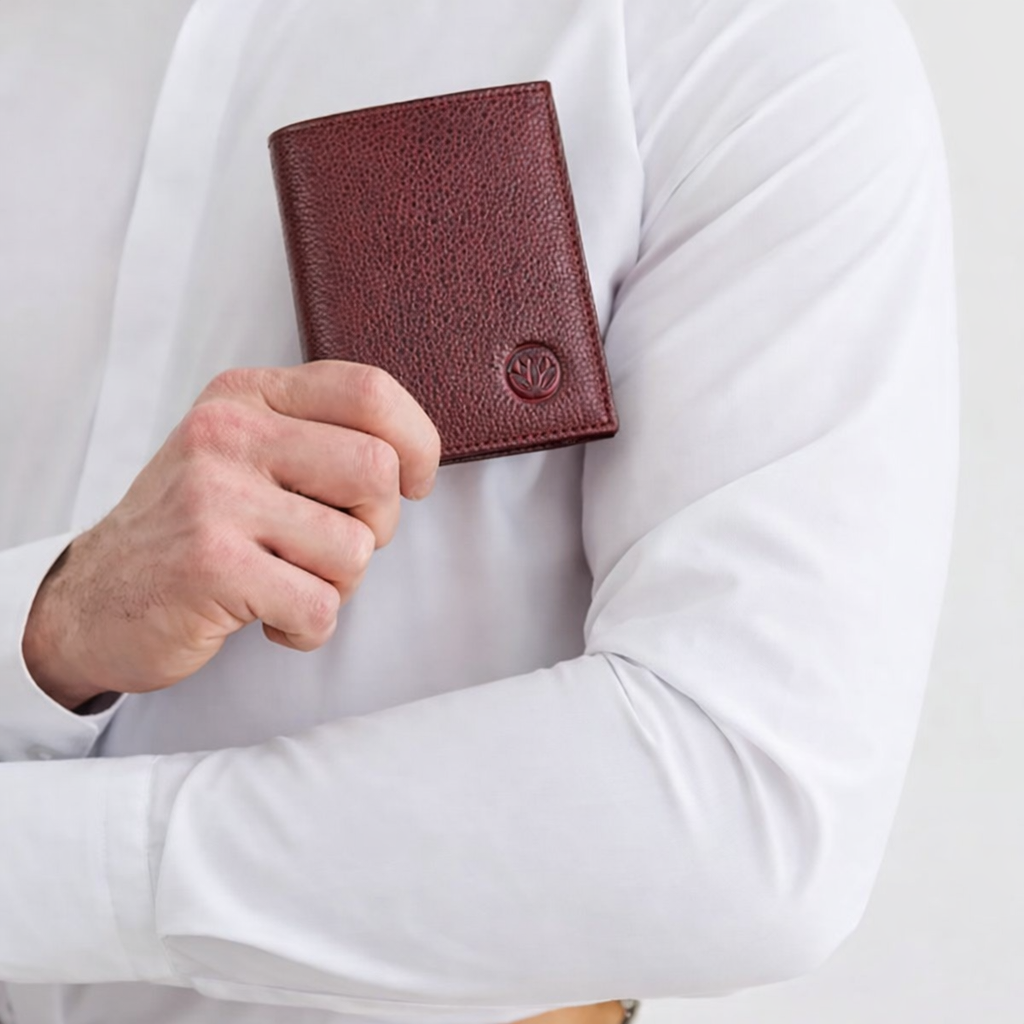 Hand holding burgundy wallet with lotus